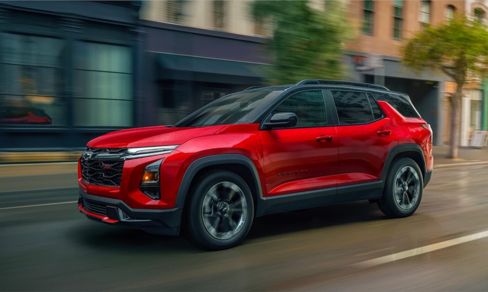 Exterior side image of a red 2026 Chevrolet Equinox RS driving on a city street