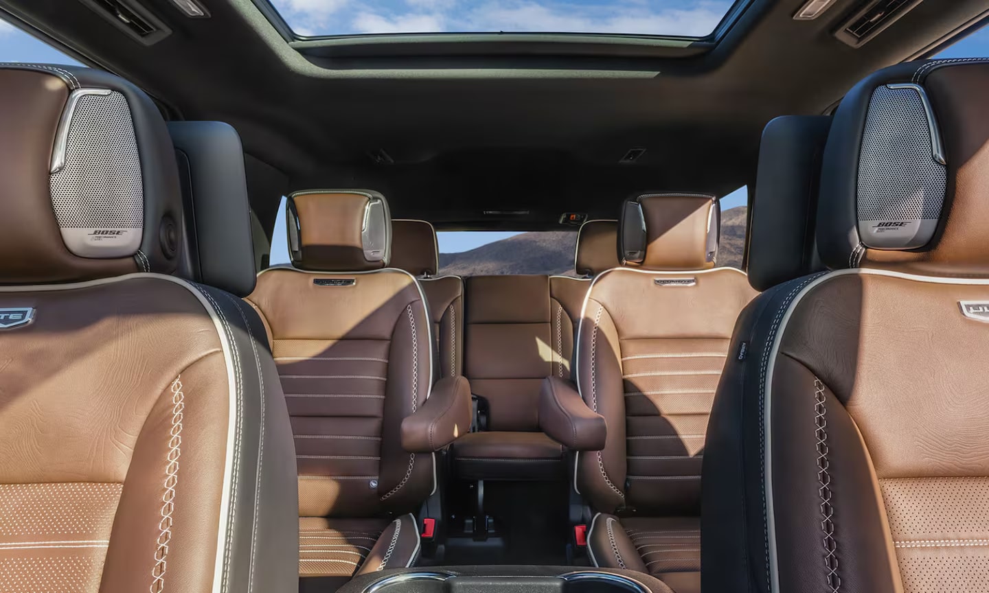 Interior front view image of the 2026 GMC Yukon three-row tan leather seats and sunroof