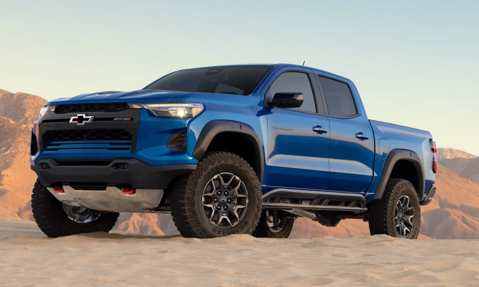 Exterior image of a blue 2026 Chevy Colorado ZR2 parked on a sandy mountain