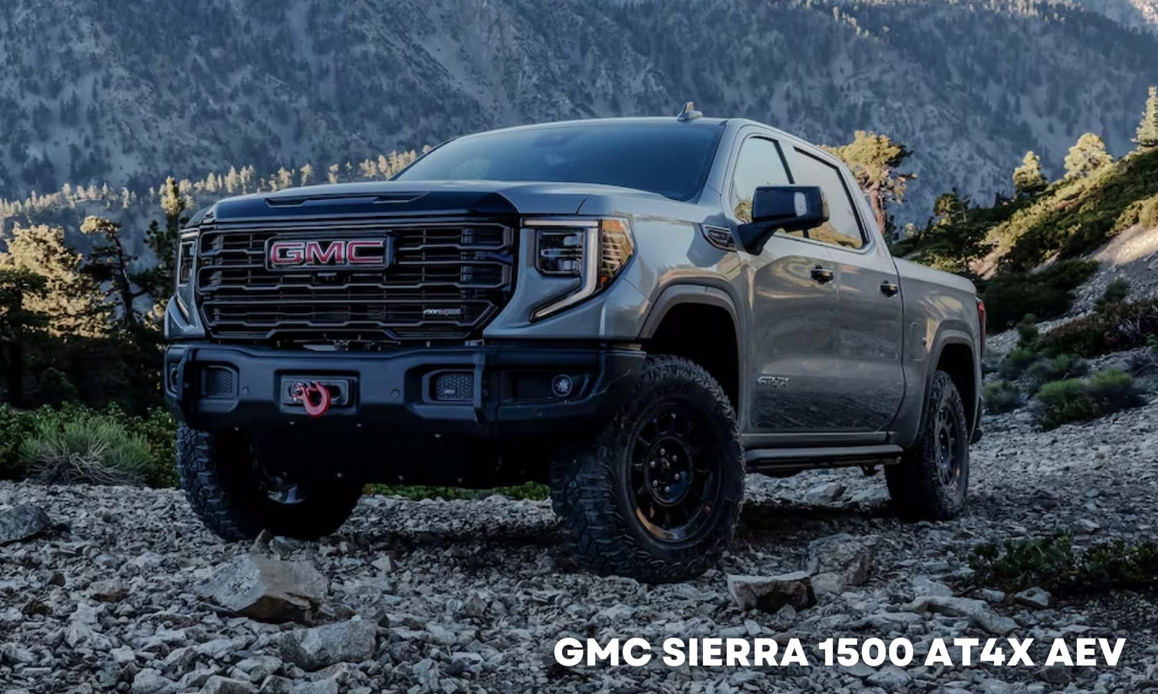 Image of a gray 2025 GMC Sierra 1500 AT4X AEV parked on a rocky mountain landscape