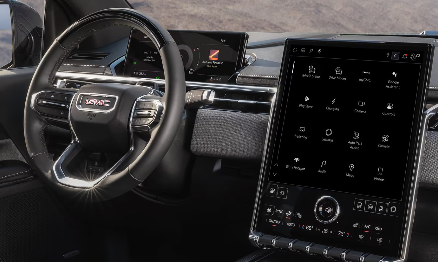 Closeup interior image of the 2026 GMC Sierra EV's black steering wheel, dashboard, and infotainment system