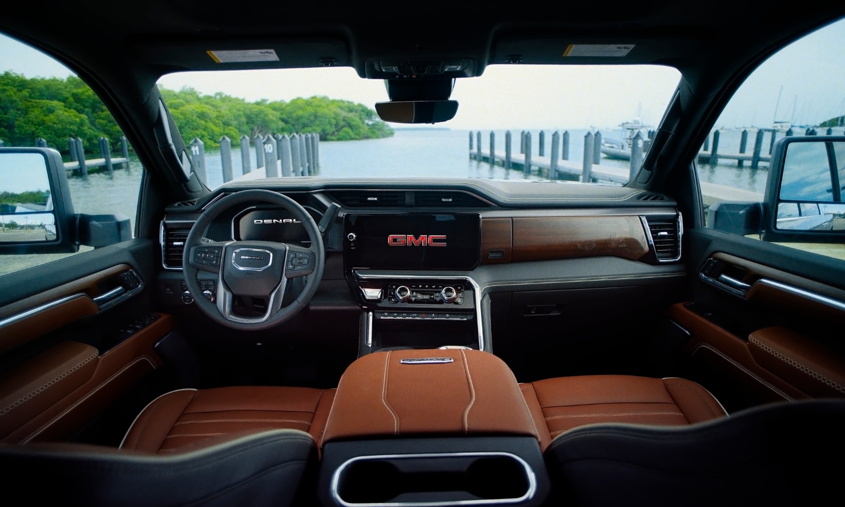 Interior image of a 2026 GMC Sierra 2500 HD Denali Ultimate front seating area with lakeside views from the windshield