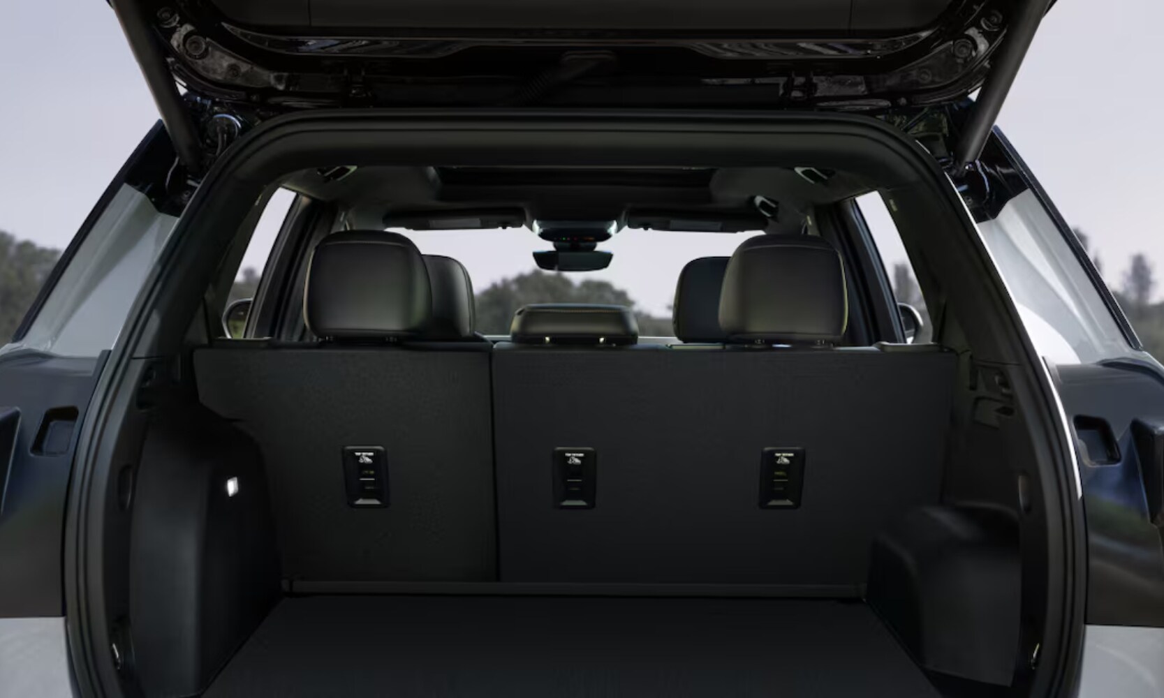 Exterior image of the 2025 GMC Acadia trunk cargo space with black colors and the door opened outside