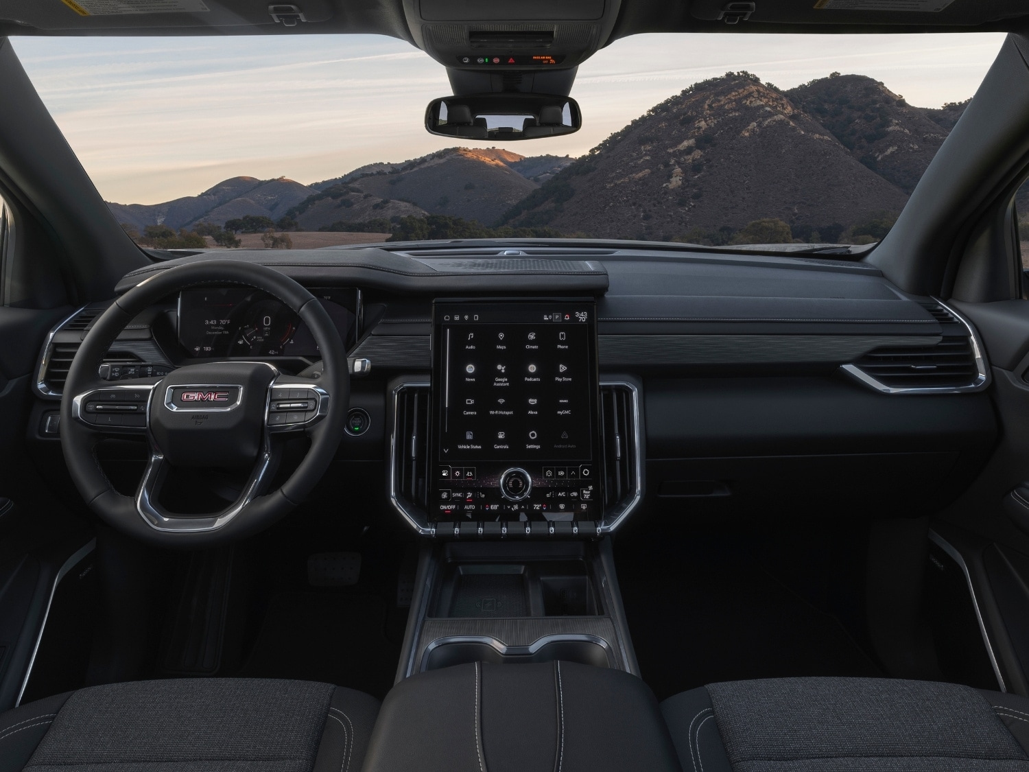 interior cabin view from the back seat of the steering wheel and dashboard inside the 2025 GMC Acadia