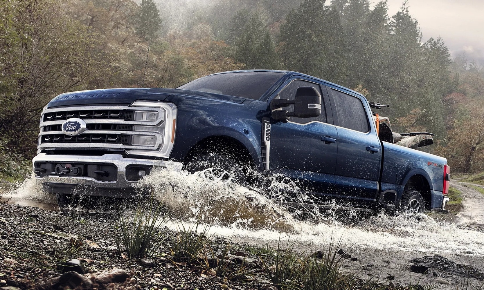 Exterior side angle image of a dark blue 2025 Ford F-250 Super Duty forging water with the FX4 Off-Road Package