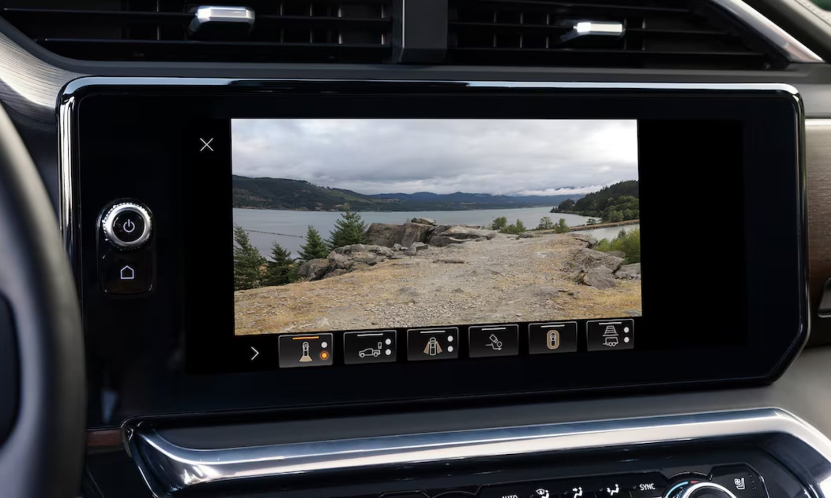 Closeup image of a 2025 GMC Sierra 1500 Denali interior dashboard camera with lake and mountain views on the screen