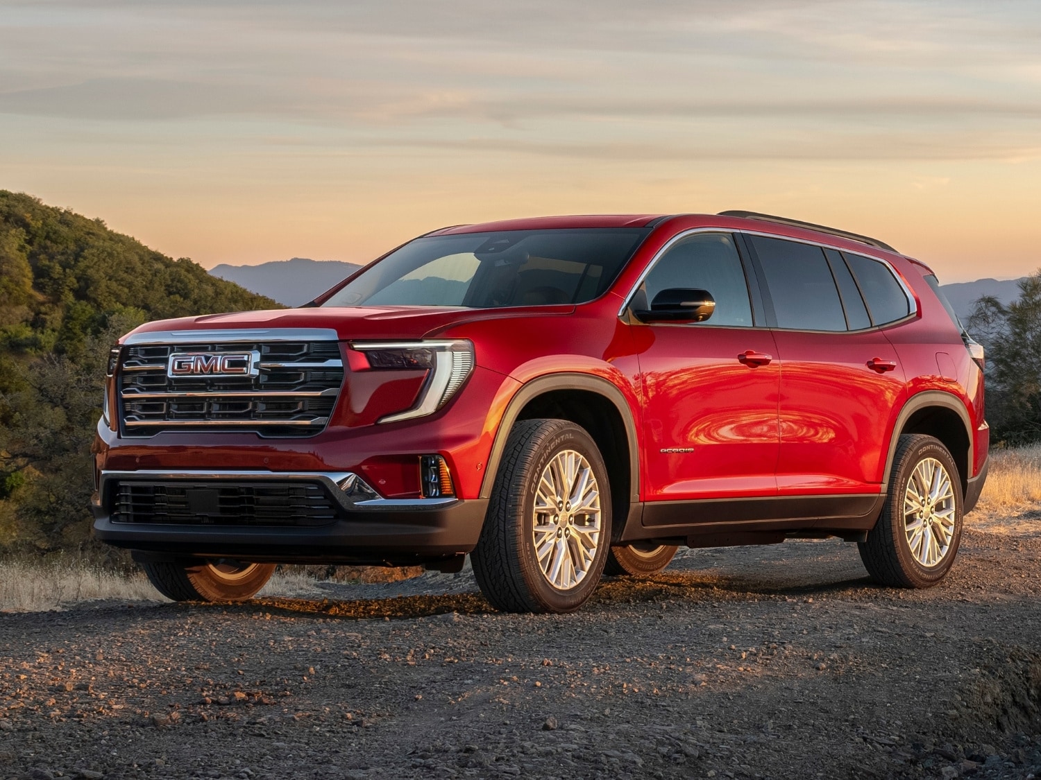 exterior driver side profile view of a red 2025 GMC Acadia Elevation SUV