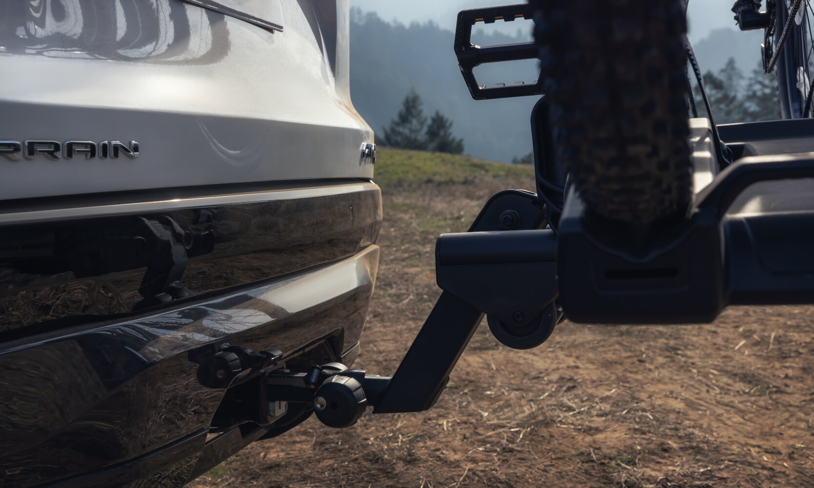 Closeup image of a white 2026 GMC Terrain with a bike mount installed on the trunk