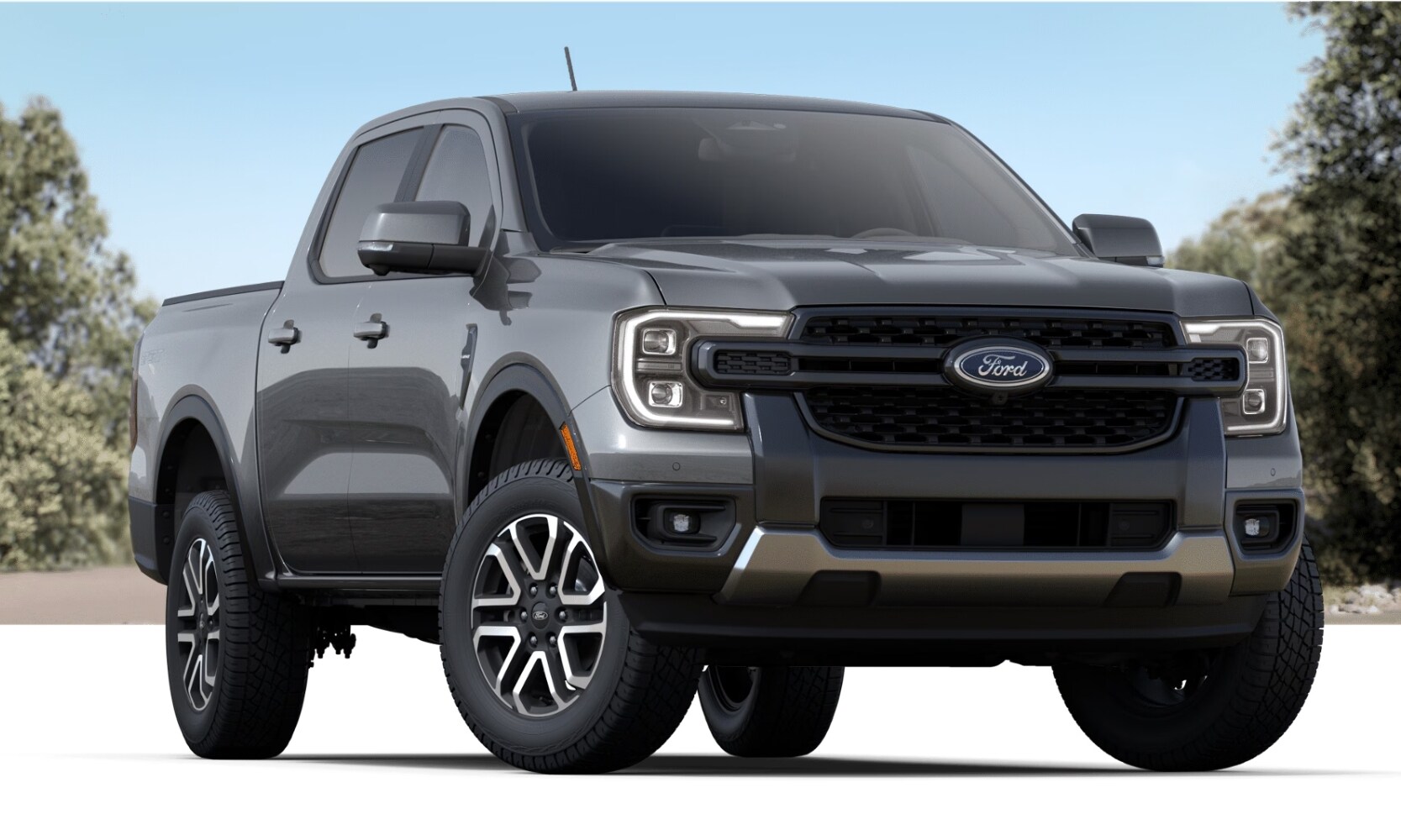 image of a dark gray 2024 Ford Ranger Lariat parked on a white floor with trees in the background