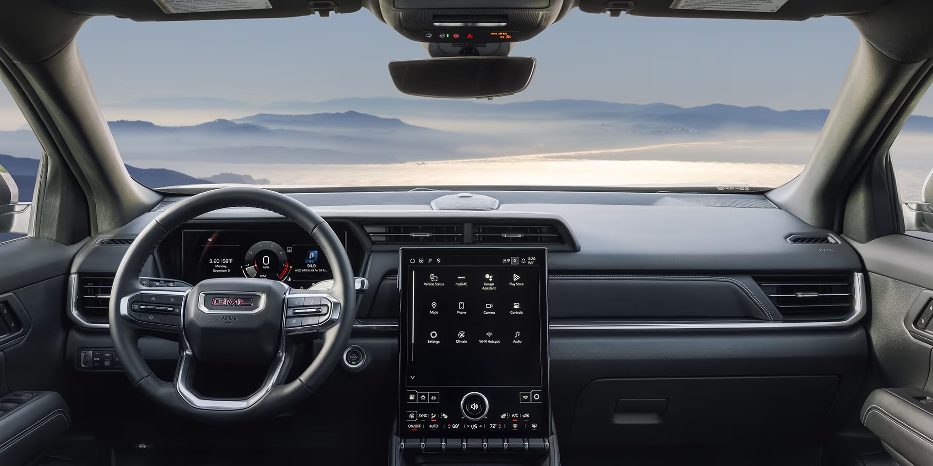 Interior image of a 2026 GMC Terrain front seating area with mountain waterfront views in the windshield