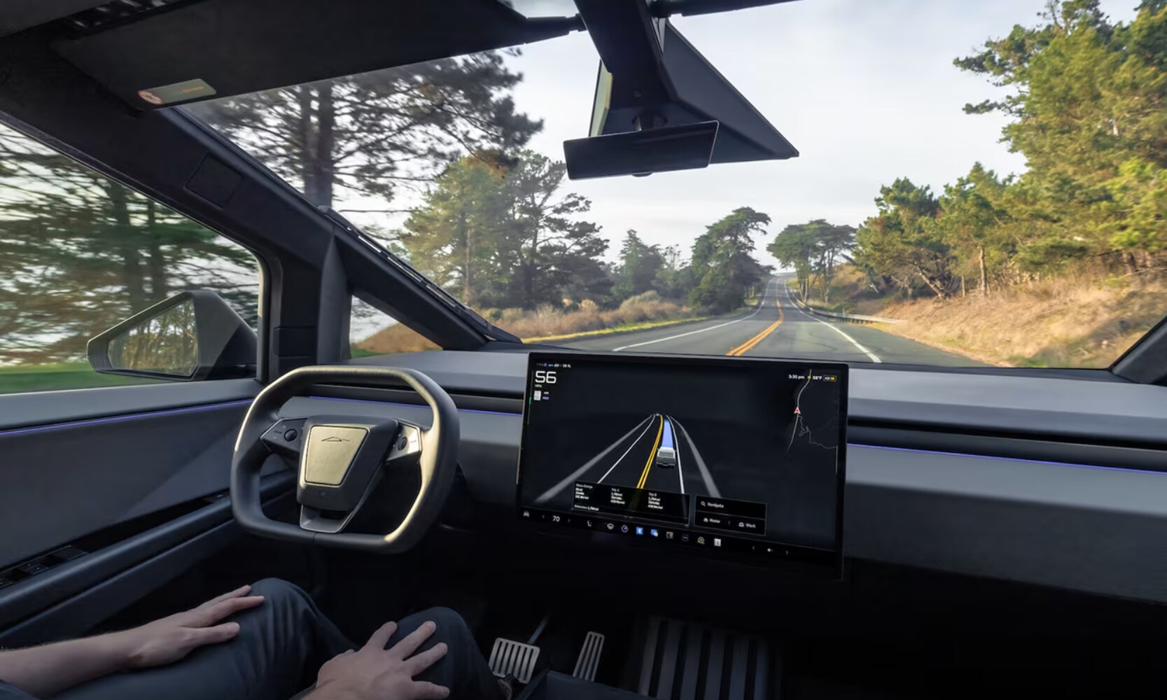 Interior image of a driver using the 2025 Tesla Cybertruck fully autonomous driving feature on a tree-lined road