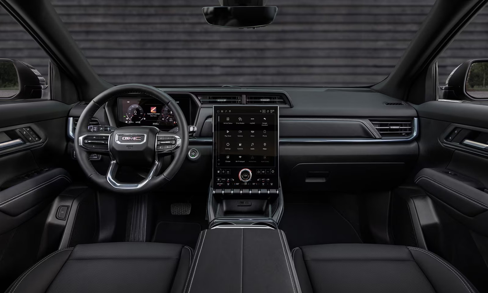 Interior image of the 2025 GMC Terrain Elevation front seat area, infotainment screen, and dashboard with blacked-out colors