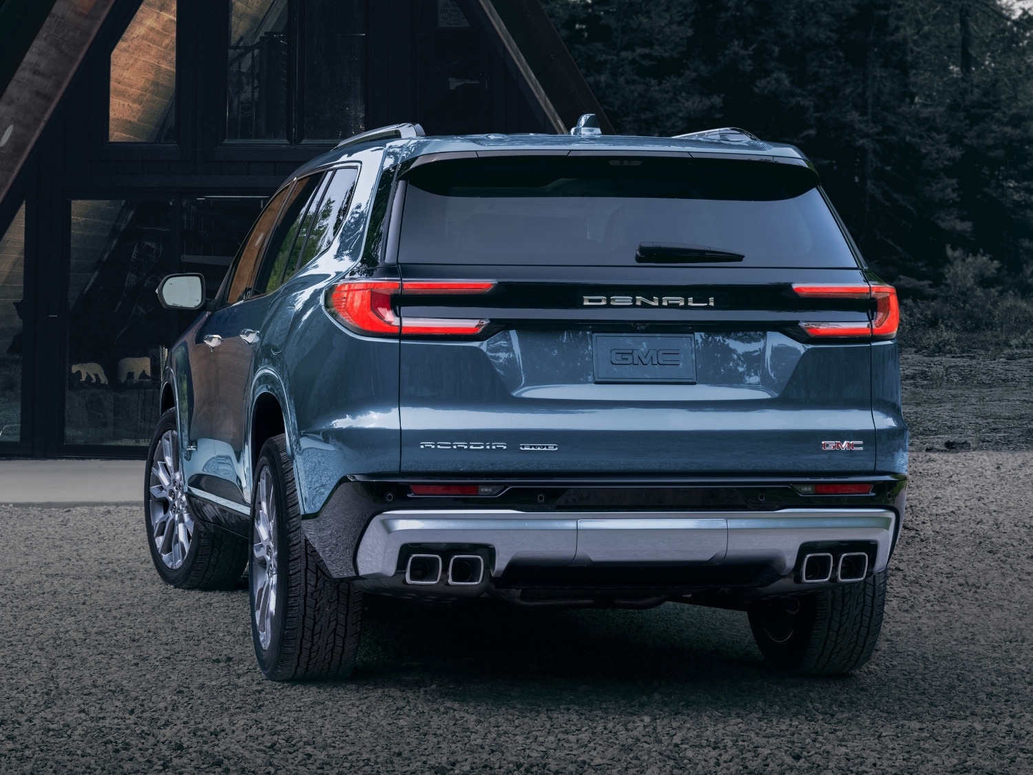 Rear exterior view of a blue 2025 GMC Acadia Denali SUV