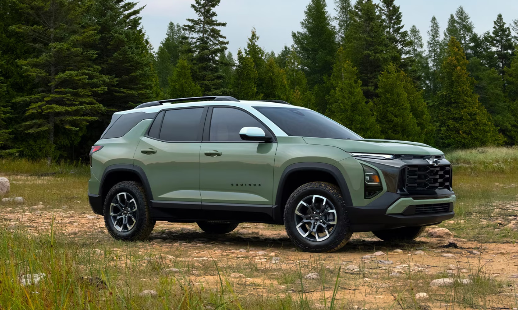 Exterior image of a light green 2026 Chevrolet Equinox ACTIV parked in an open forest field