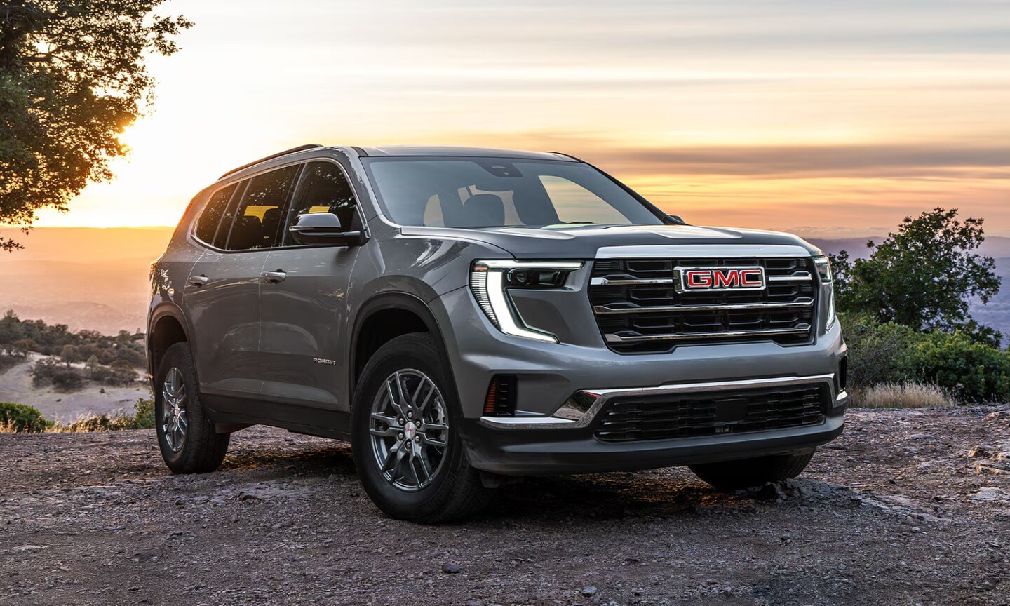 Exterior image of a gray 2026 GMC Acadia Elevation parked on a mountain