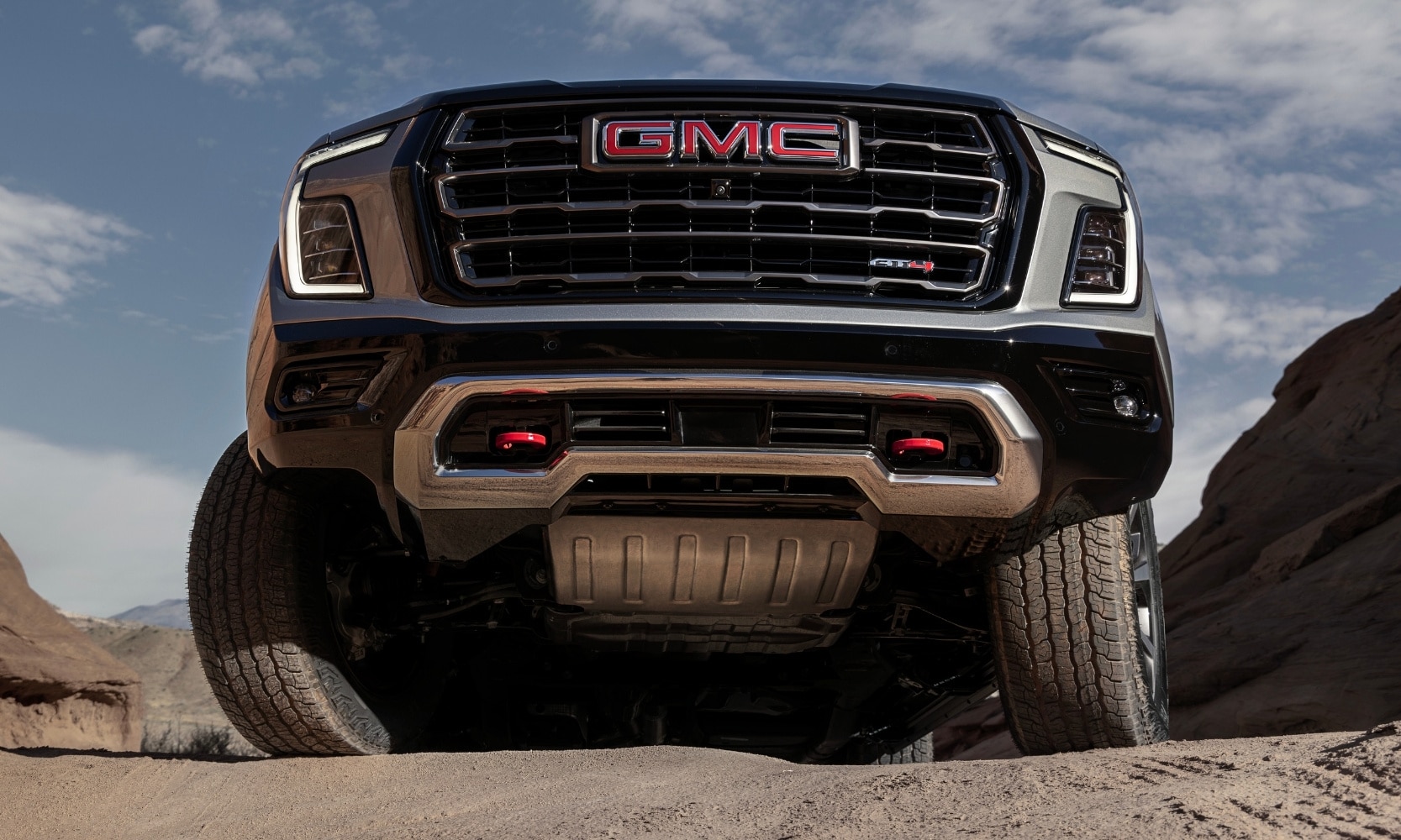 a 2025 GMC Yukon AT4 model undercarriage driving over off-road terrain