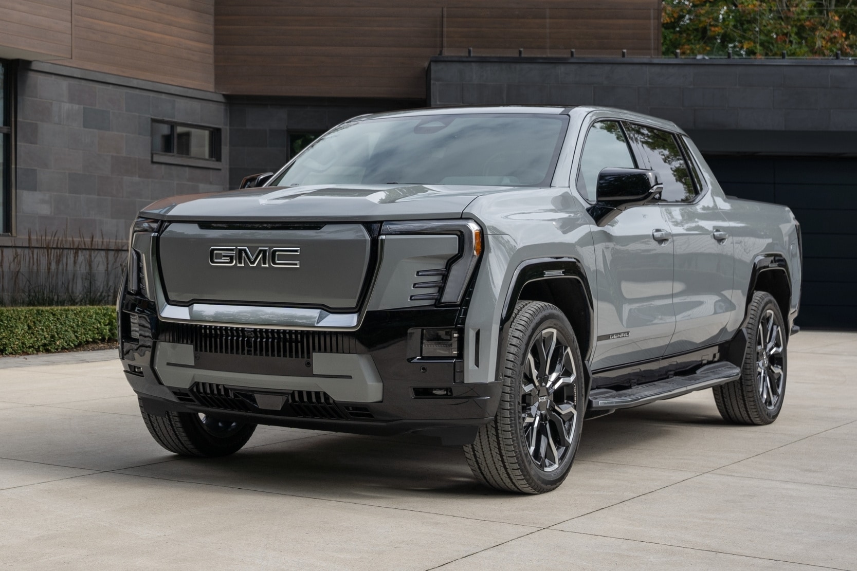 Front profile view of a 2025 GMC Sierra EV Denali parked in a modern drive way