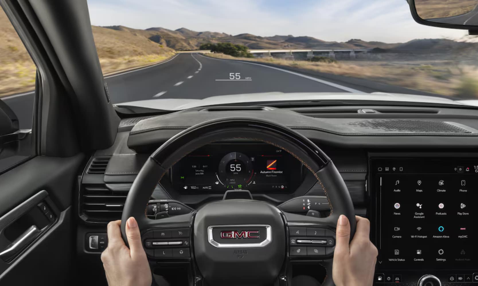 Interior image of a 2025 GMC Acadia AT4 Head-Up Display with a driver's hands driving