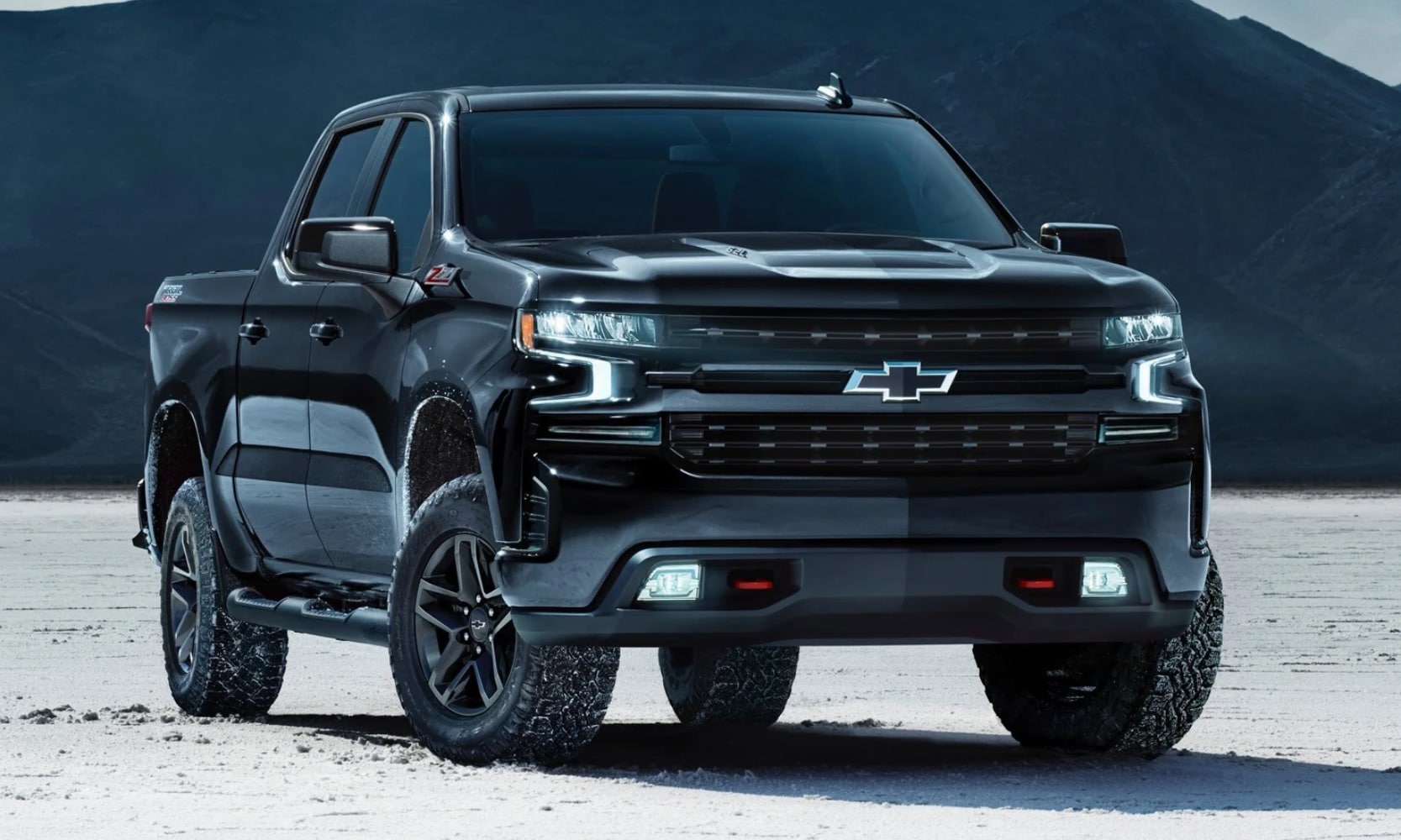 Exterior front image of a black 2020 Chevy Silverado 1500 parked in an open snowy mountainous setting