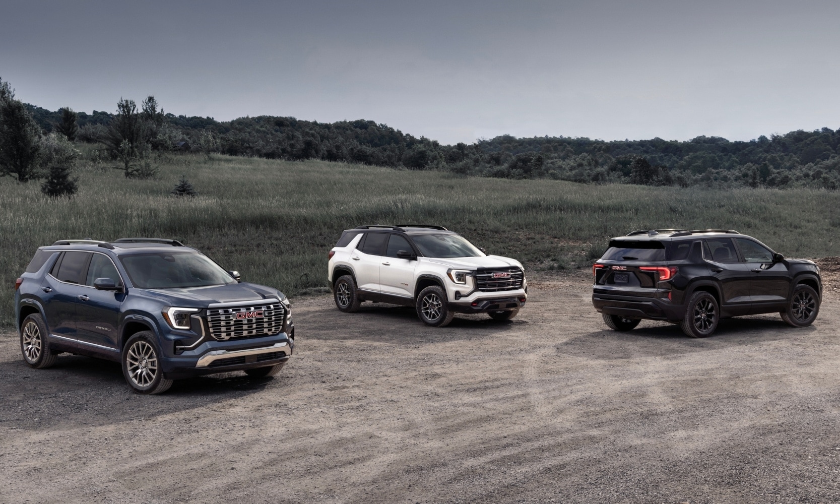 an image showing the 2025 GMC Terrain Elevation, 2026 GMC Terrain AT4, and the 2026 GMC Terrain Denali side by side