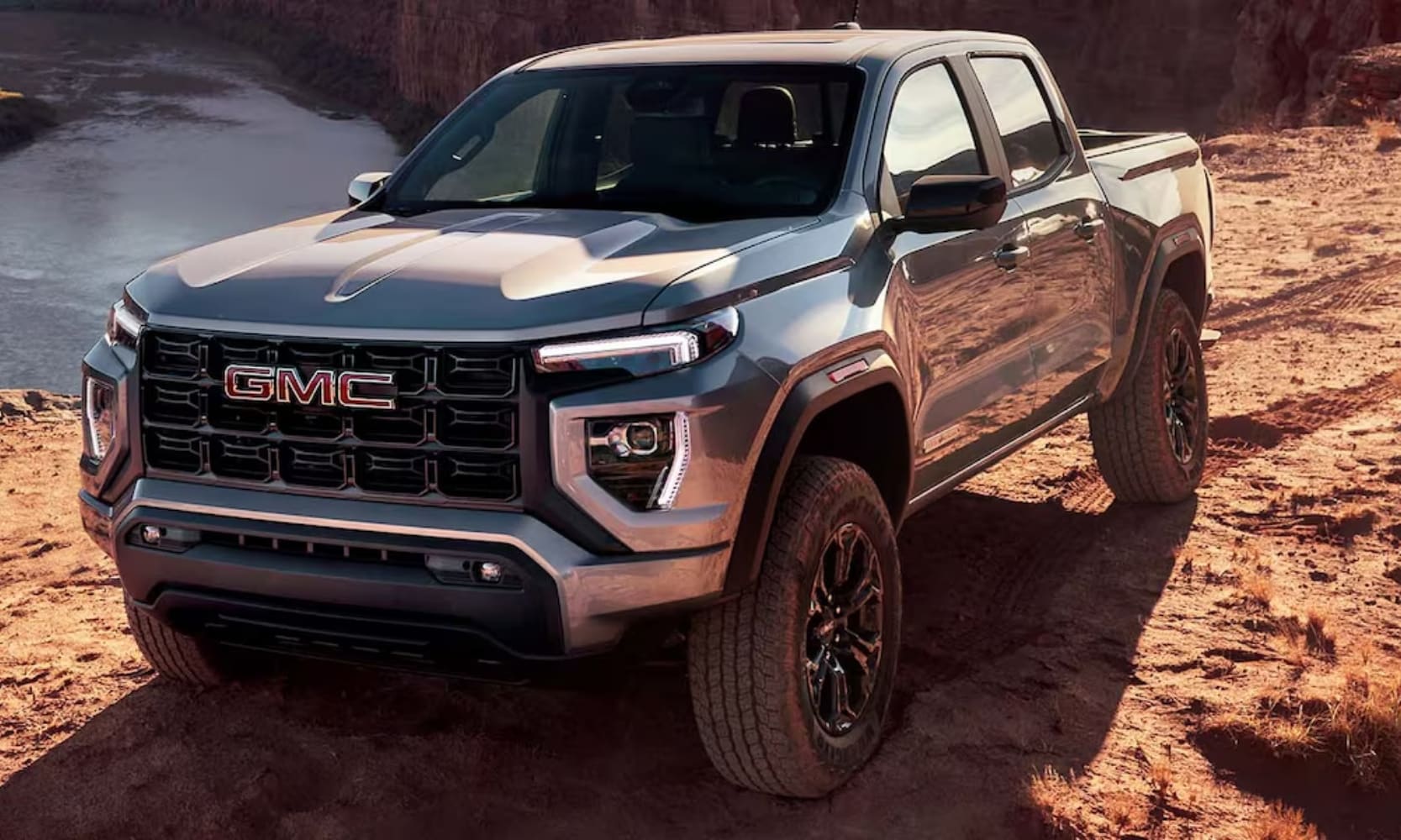 image of a silver 2024 GMC Canyon Elevation parked on a mountain with water in the background