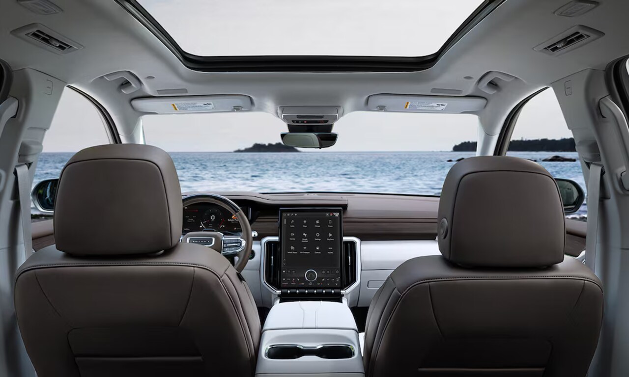 Interior image of a 2026 GMC Acadia front seating area with beach views in the windshield