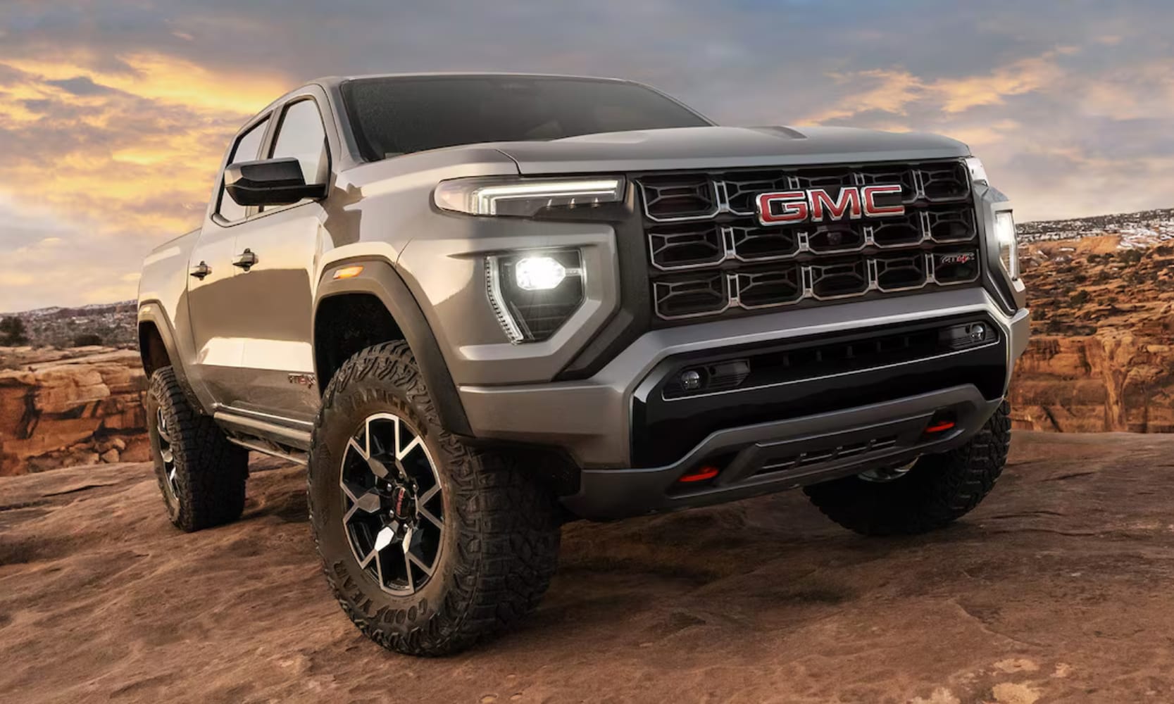 Close-up fish lens front view of a light gray 2026 GMC Canyon parked on top of a rocky mountain