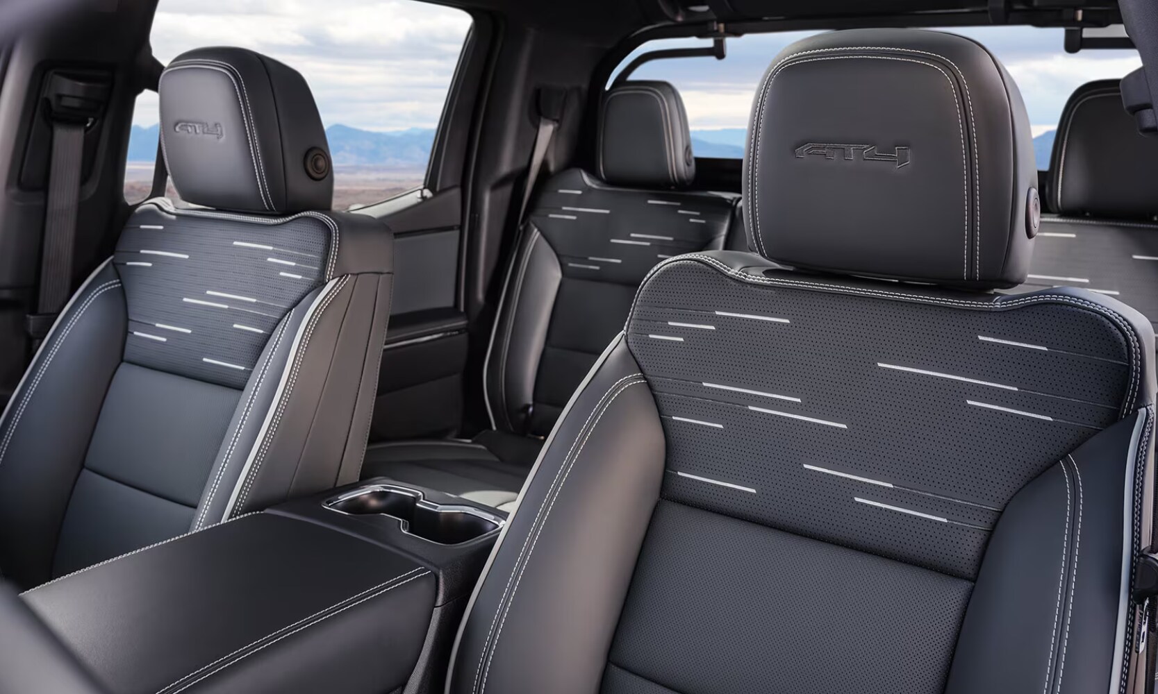 Closeup interior image of the 2026 GMC Sierra EV AT4's gray leather seats with mountain window views
