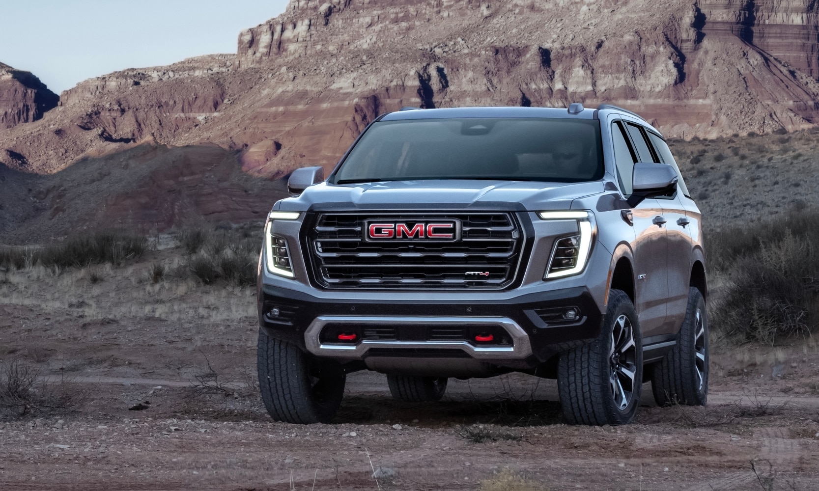 Profile view of a 2025 GMC Yukon AT4 model with daytime running LED headlights