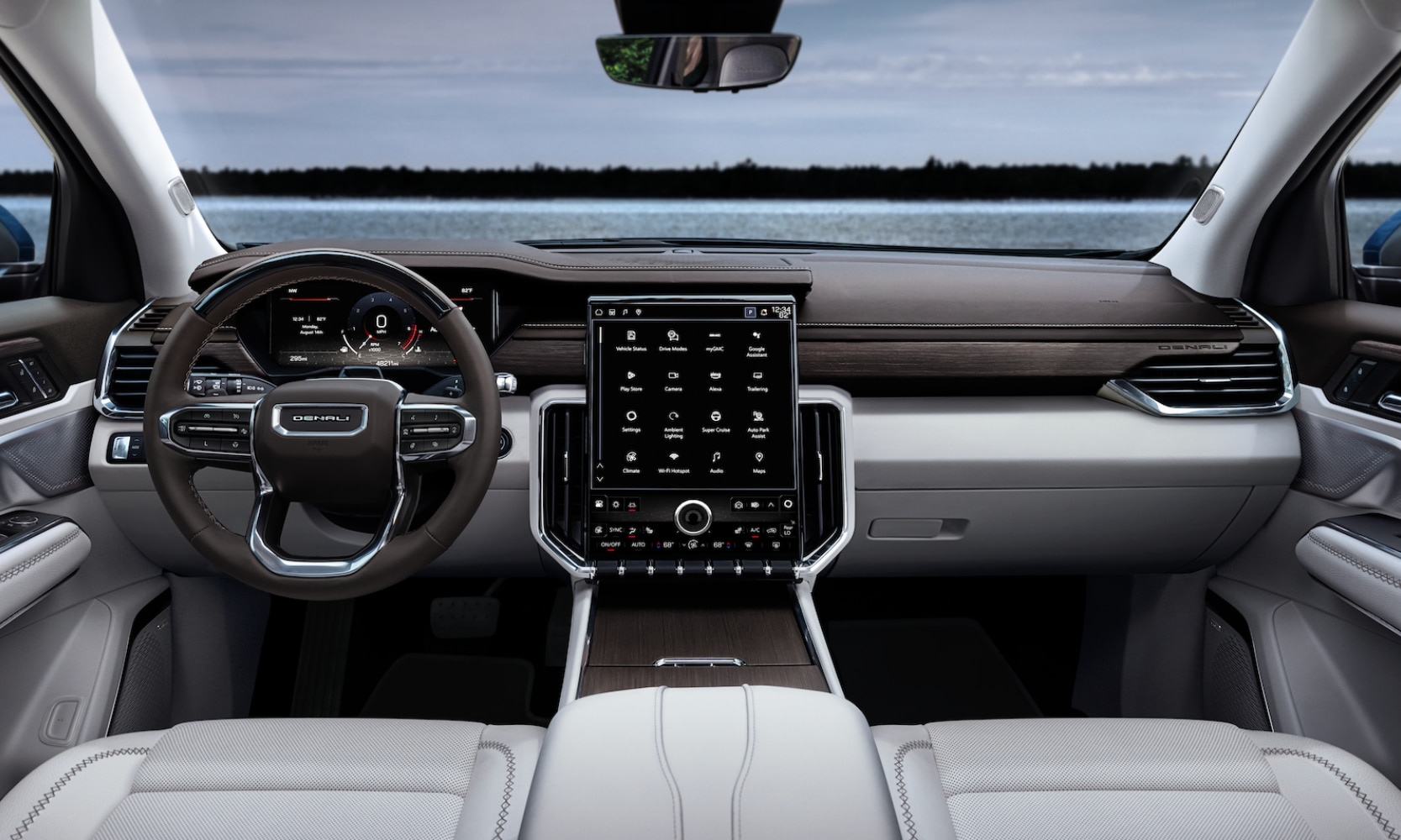 Interior image of a 2024 GMC Acadia Denali front seating area with white leather seats and waterfront windshield views