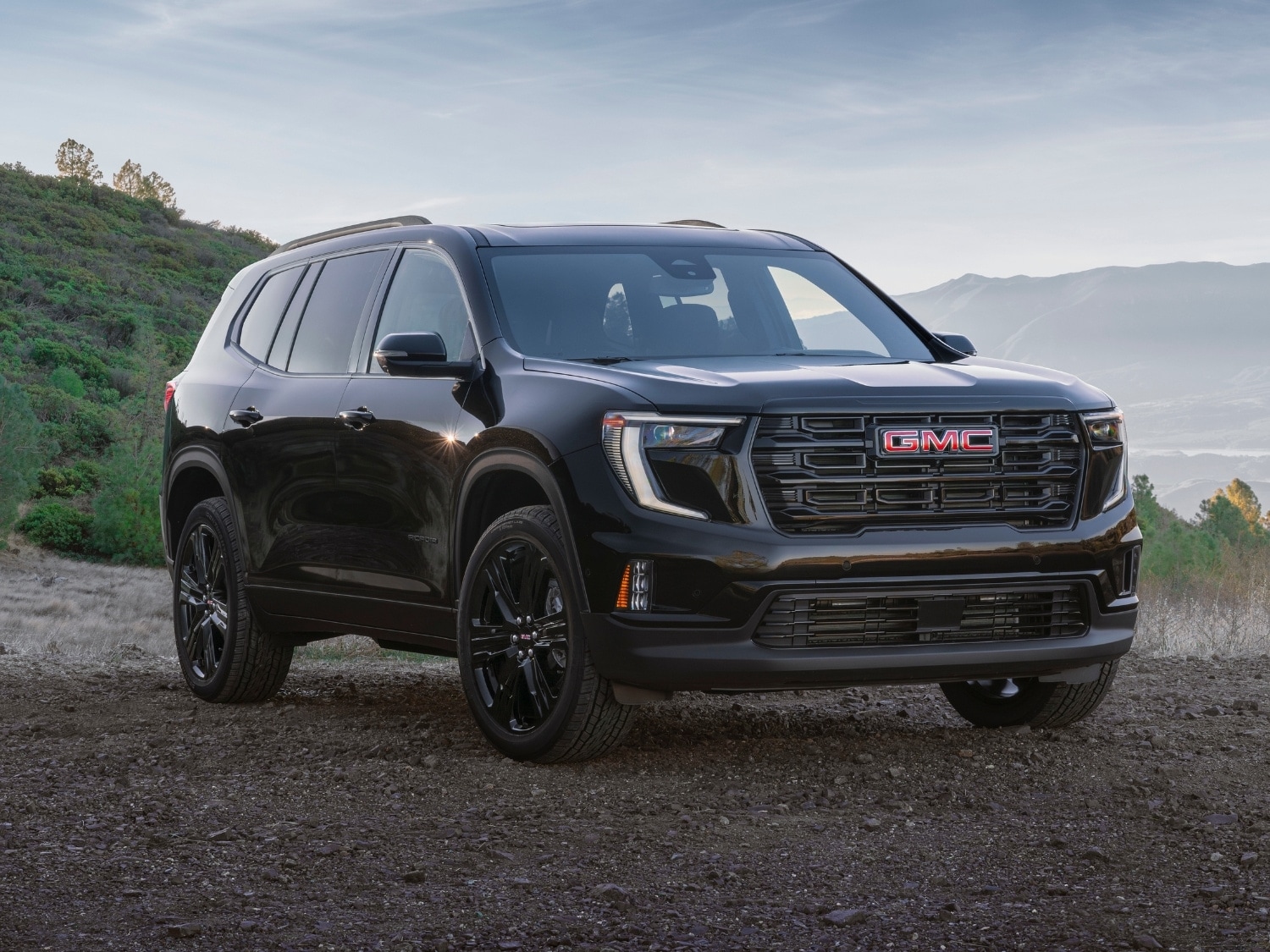 front exterior passenger side profile view of a black 2025 GMC Acadia Elevation model equipped with the Elevation Premium package