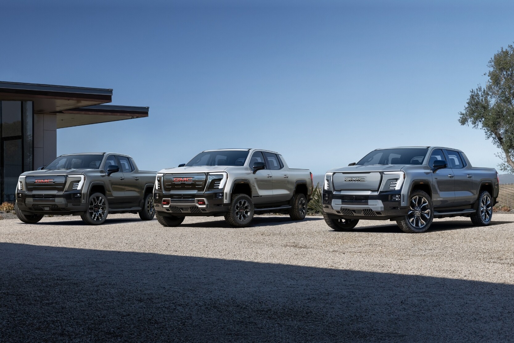 2025 GMC Sierra EV Elevation on the left with the 2025 GMC Sierra EV AT4 in the middle next to a 2025 GMC Sierra EV Denali on the right