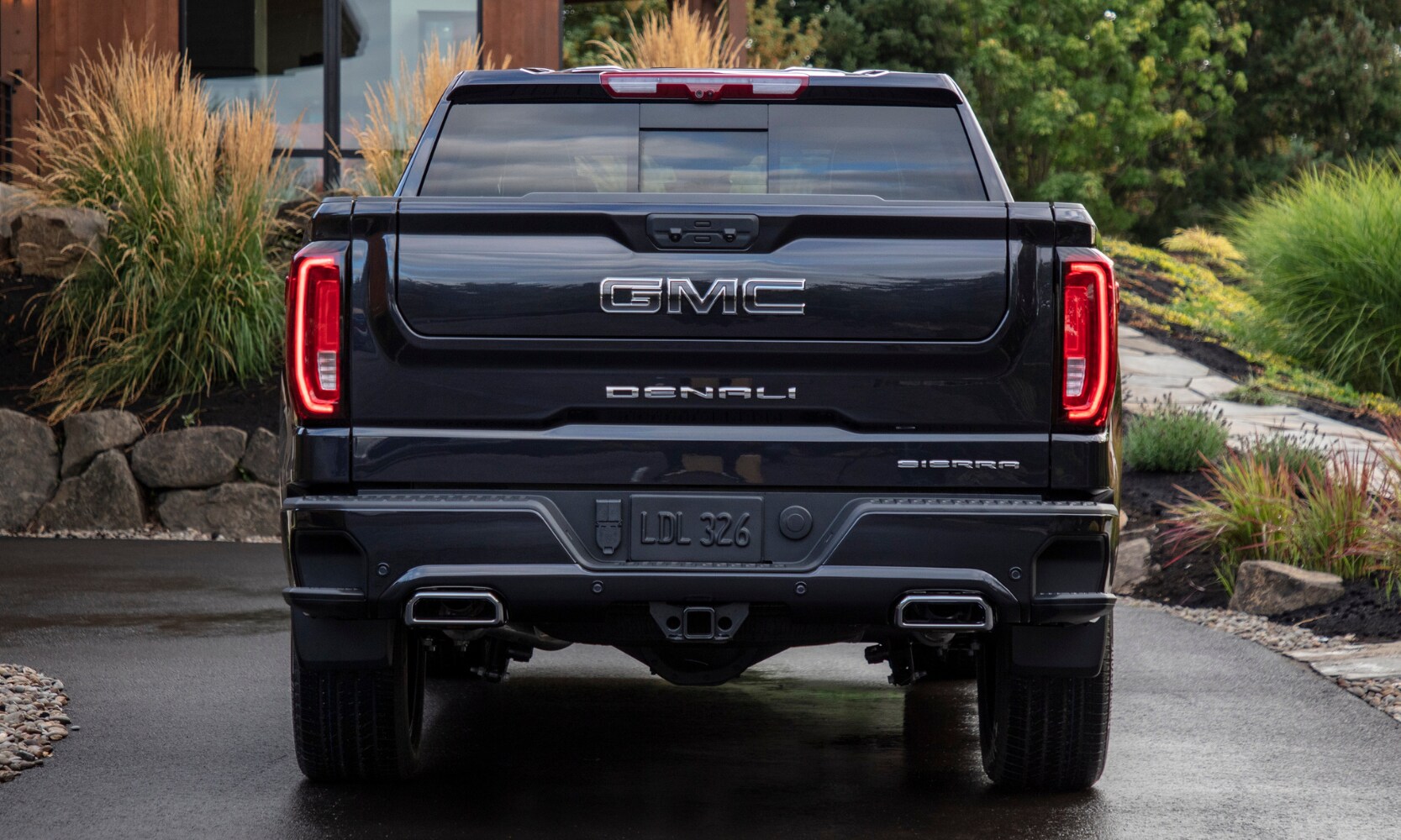 Rear exterior tailgate view of the New 2022 GMC Sierra 1500 Denali truck showing off dual exhaust and unique tailgate technology