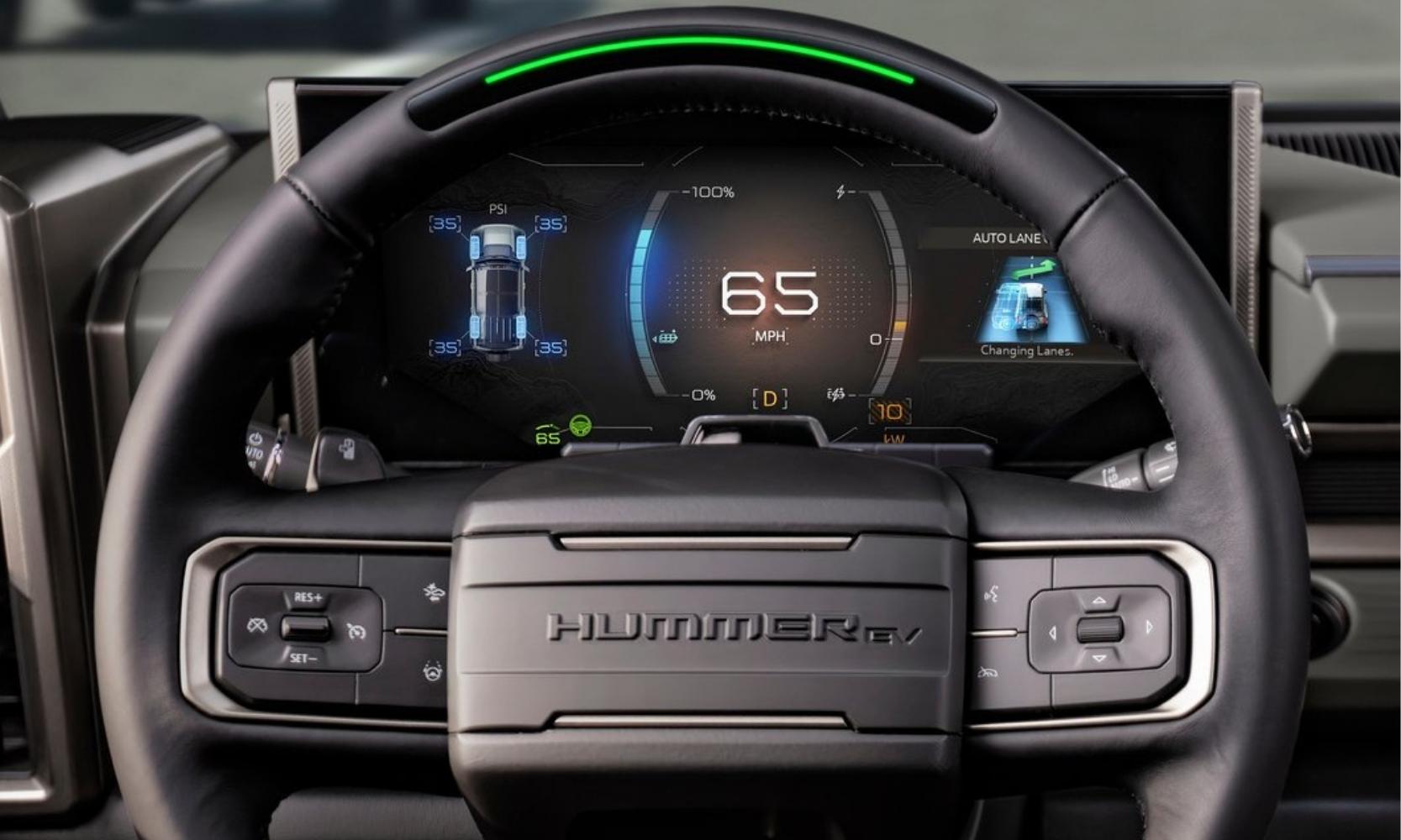 Close up view of the steering wheel inside the 2024 GMC Hummer electric SUV showing the Super Cruise strip on the steering wheel and the digital instrument panel that houses the auto lane change interface