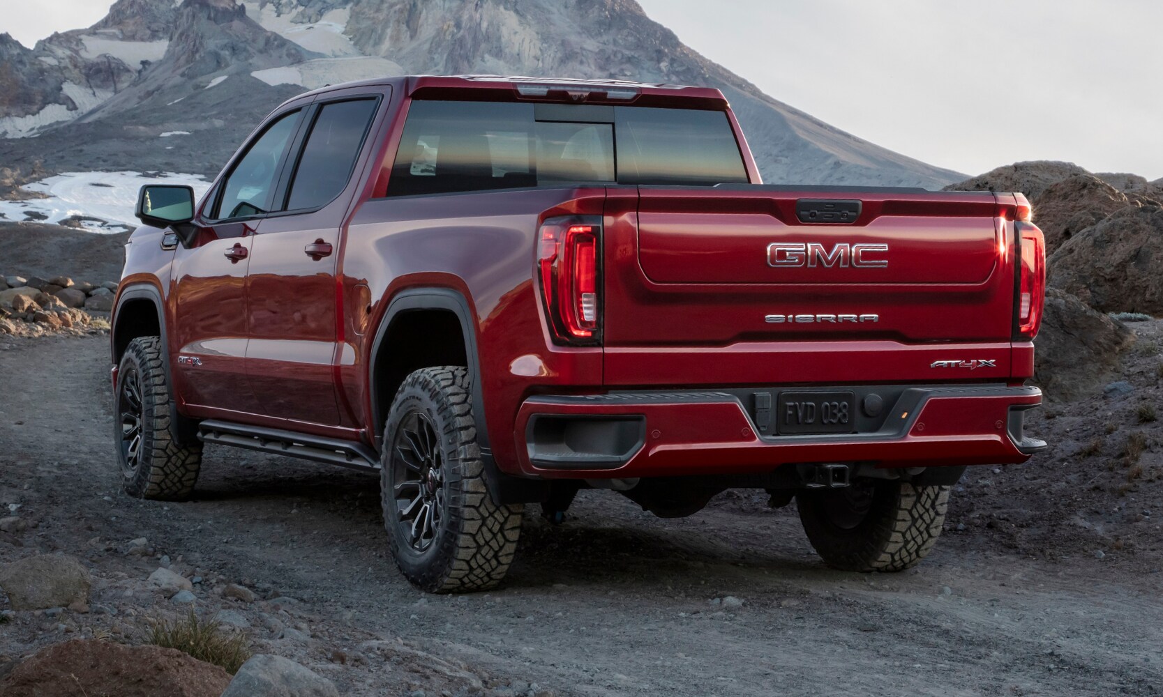 Rear exterior view of the New 2022 GMC Sierra 1500 AT4X truck going off-road through some rocky mountain trails