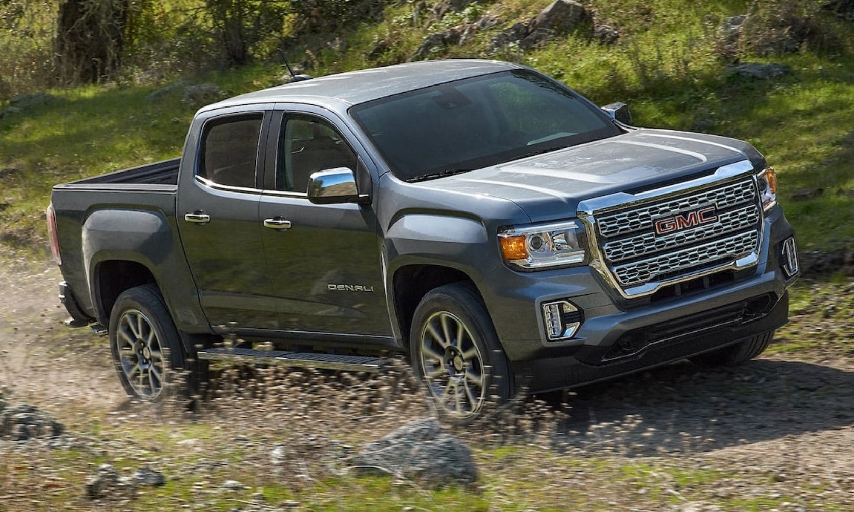 GMC Canyon Denali driving down a rocky path through some woods