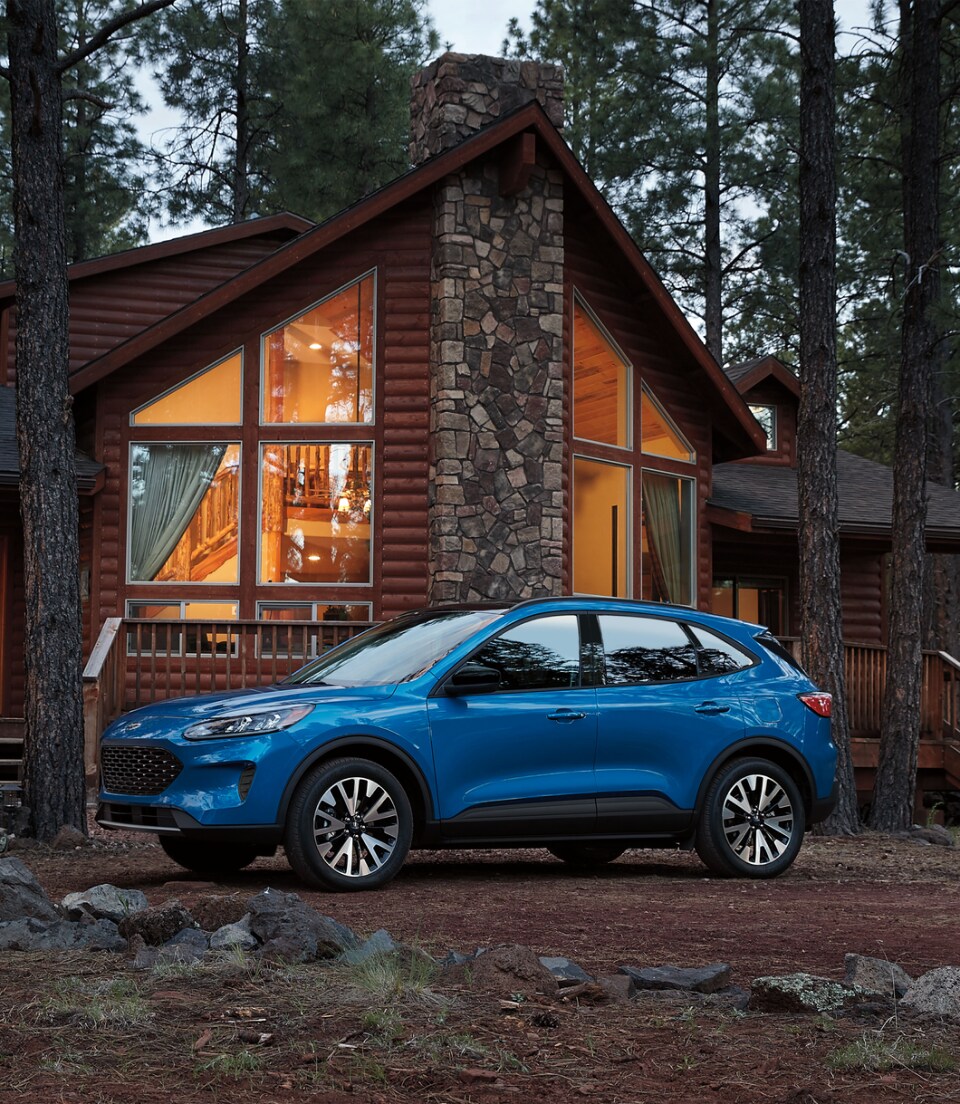 2024-Ford-Escape-SE-Sport-SUV.png blue Ford Escape SUV parked in front of a lodge