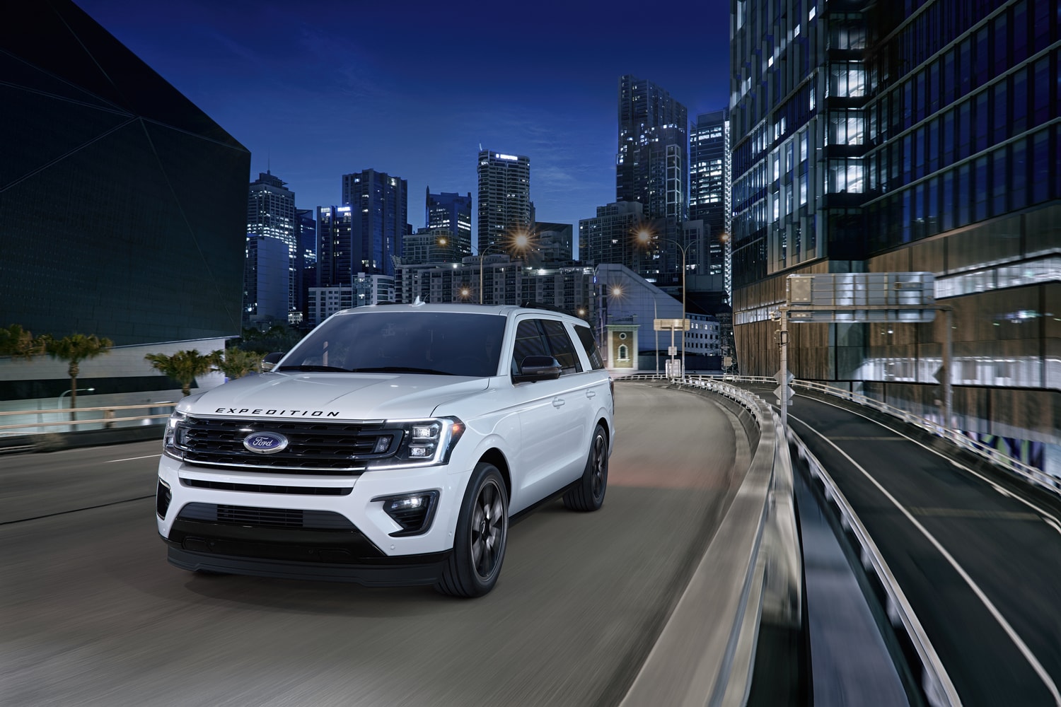 white Ford Expedition SUV driving through a city at night