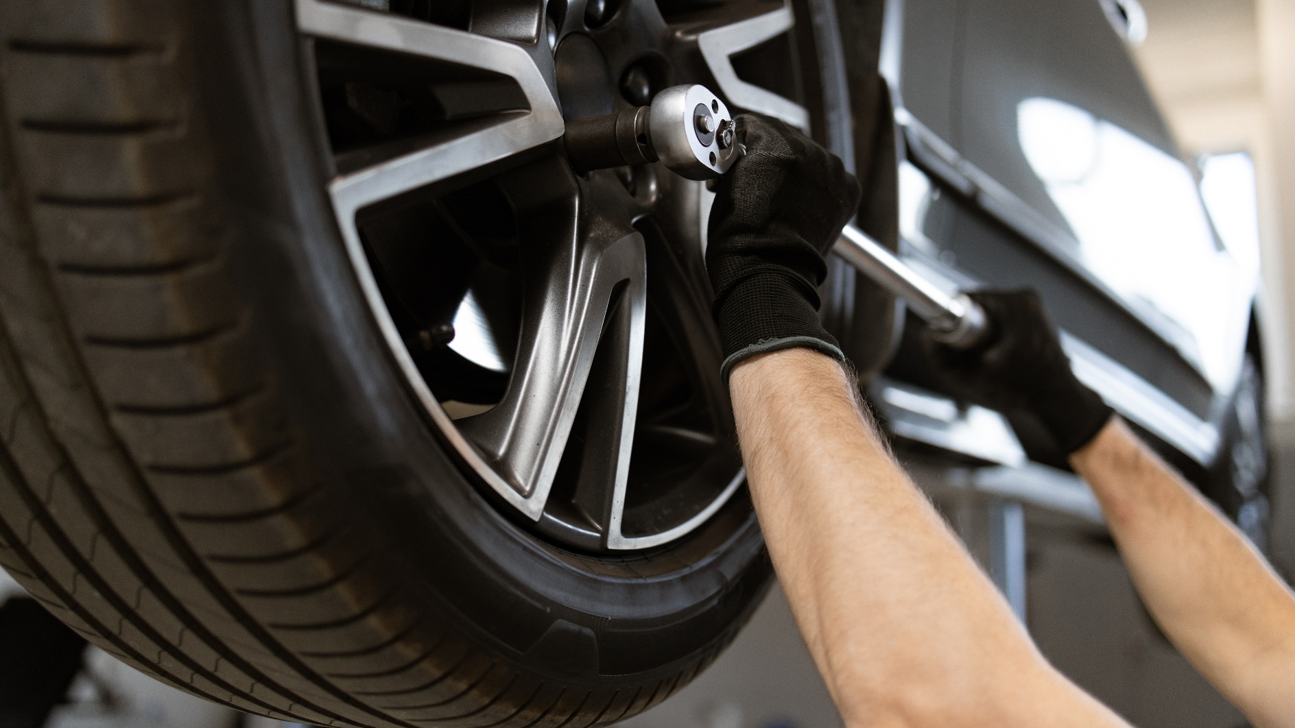 A mechanic performing tire maintenance on a vehicle.