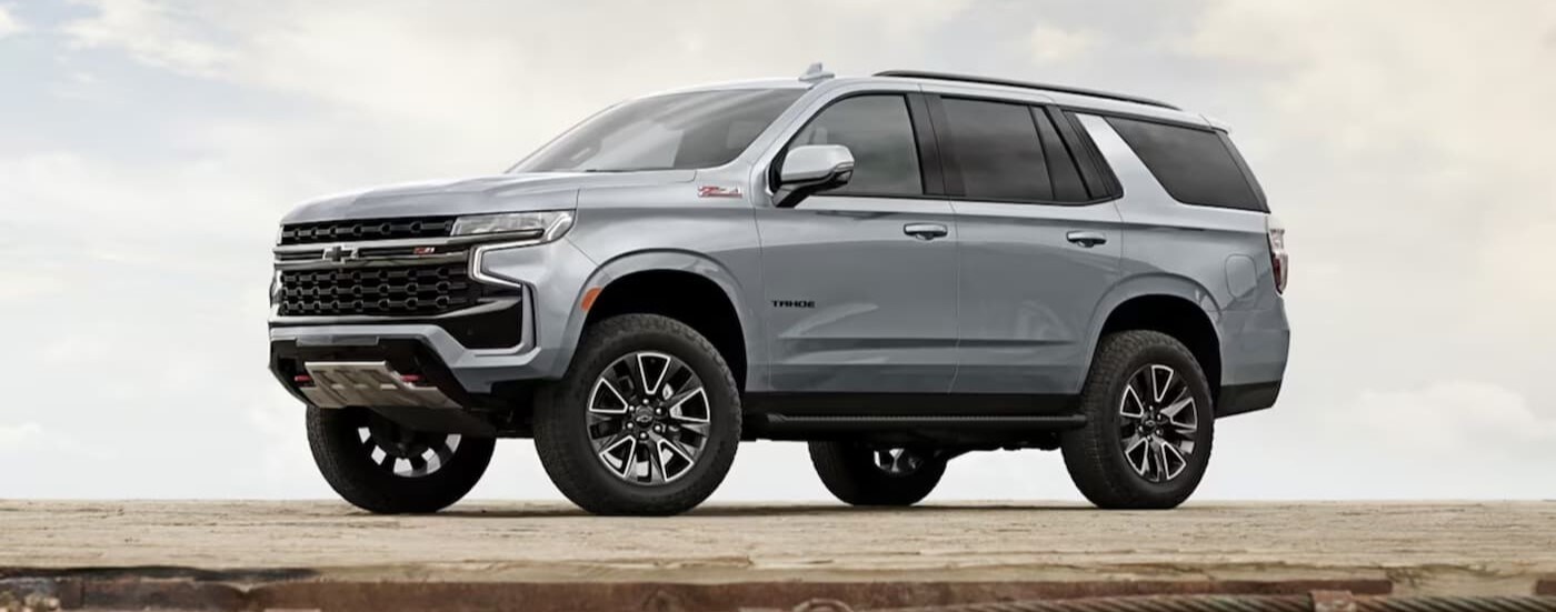 A popular Chevy Tahoe for sale, a silver 2024 Chevy Tahoe Z71, is shown parked off-road.