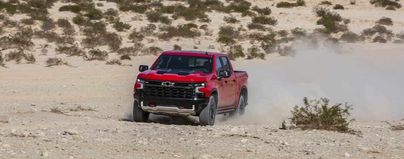 A red 2022 Chevy Silverado 1500 ZR2 is shown from the front at an angle after leaving a dealer that has a Chevy Silverado for sale.