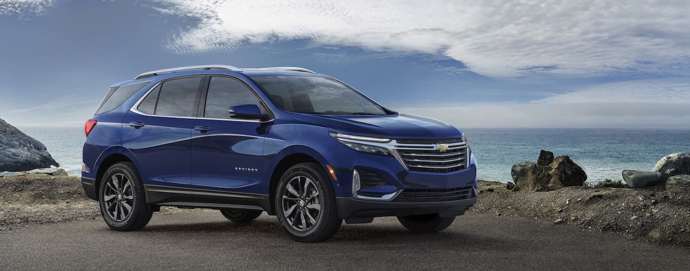 A blue 2022 Chevy Equinox Premier is shown from the side at an angle after leaving a dealer that has a Chevy Equinox for sale.