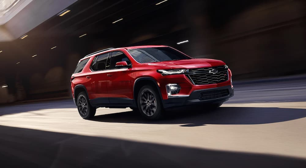 A red 2023 Chevy Traverse RS driving on a highway near an Alexandria, VA Chevy dealer.