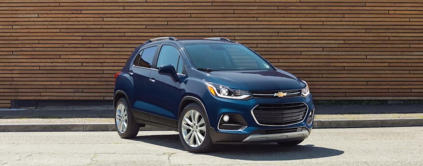 A blue 2019 Chevy Trax parked in front of brown wall at a used Chevrolet dealer.