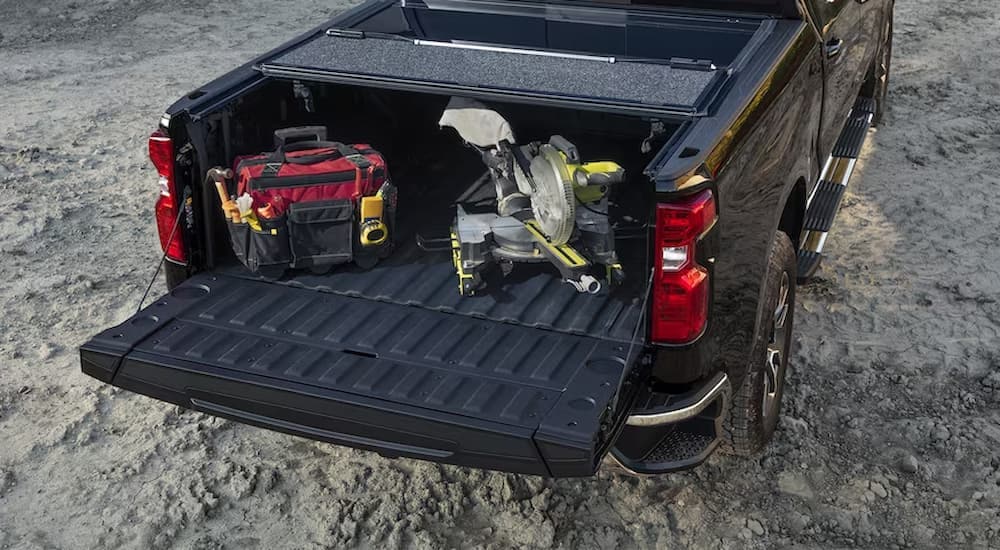 The bed of a black 2024 Chevy Silverado 1500 is shown full of tools.