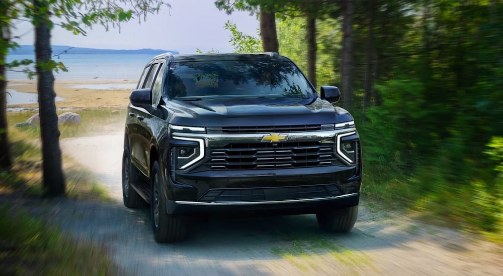 A black 2025 Chevy Tahoe driving from a shore.
