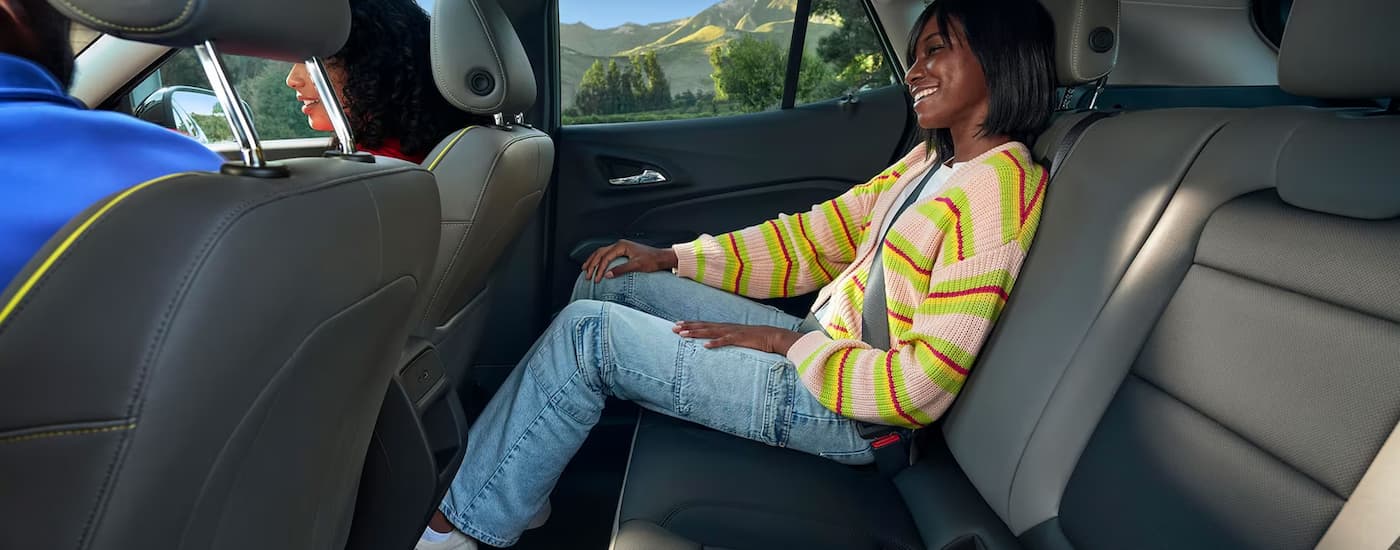A person is sitting in the back seating of a 2024 Chevy Trax.