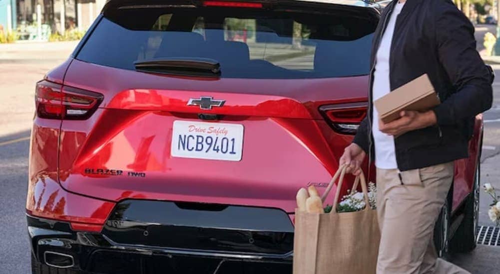 2024%20Chevy%20Blazer%20RS%20-%20Rear.jpg A person is shown walking near the rear of a red 2024 Chevy Blazer RS