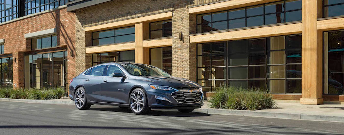 A grey 2021 Chevy Malibu for sale is shown from the front at an angle.