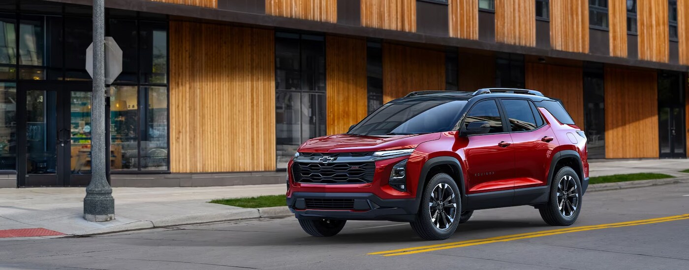 A red 2025 Chevy Equinox RS stopped at a city intersection.
